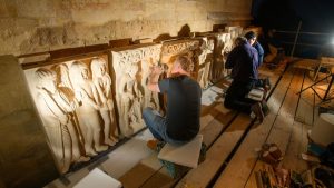 Artists on scaffolding carving stone