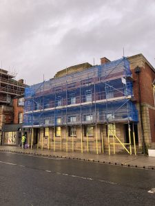 scaffolding on a building by a busy road in Lincoln