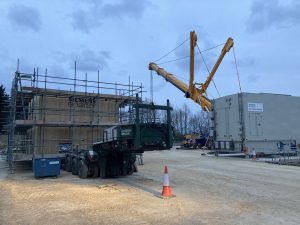 scaffolding surrounding a covered gas compressor on a construction site