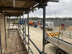 scaffolding surrounding a covered gas compressor on a construction site